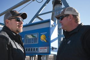 Eric (left) and Jeremy Arnold adjust a pivot.