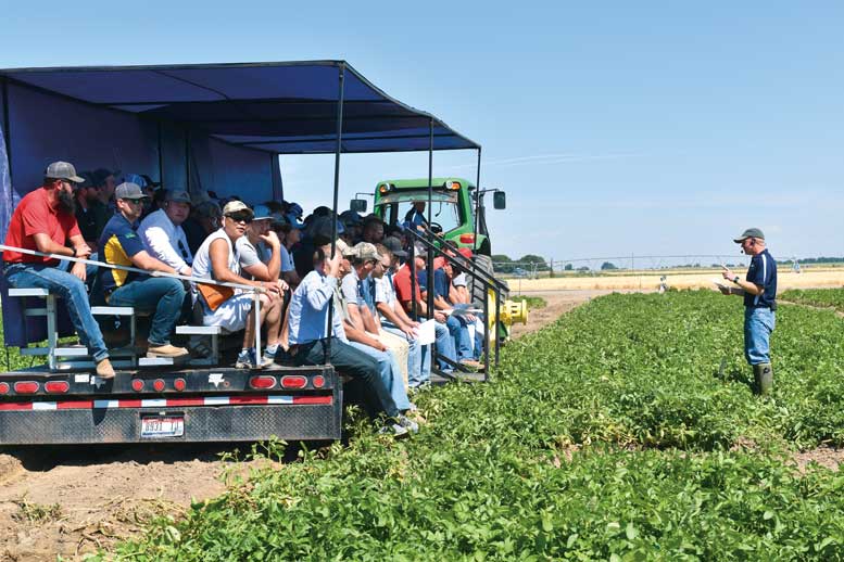 Attendees at the Miller Research Potato Pest Management Field Day inspect test plots as Jeff Miller explains what they are seeing.