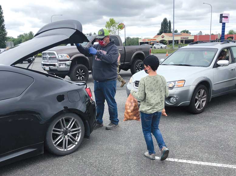 WSPC commissioner Jordan Reed and his son Owen Reed volunteer at a potato giveaway event in Auburn, Wash.